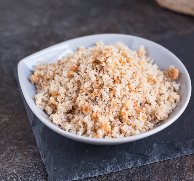 A small grey bowl full of fresh breadcrumbs made from stale bread.