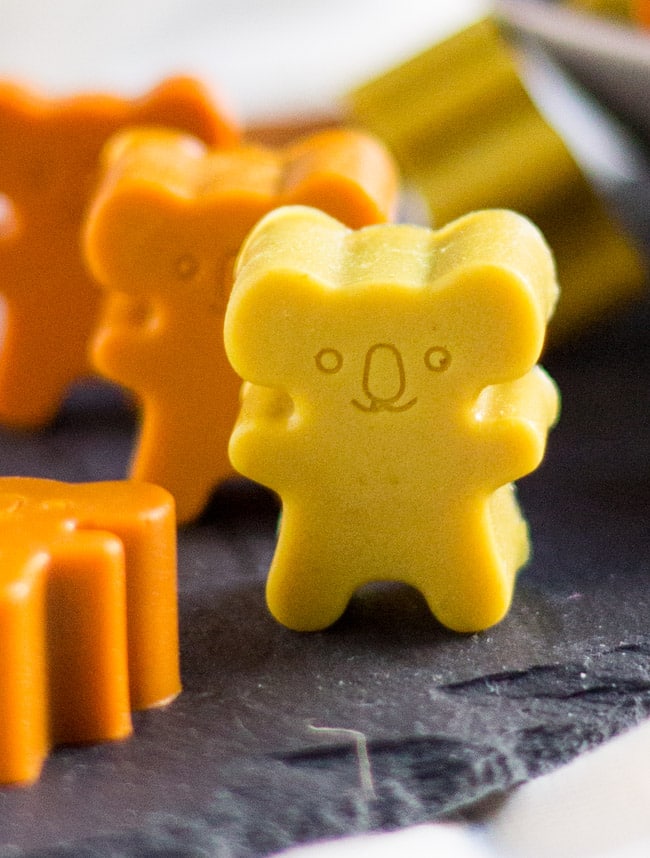 A close up of a yellow Cold Busting Coconut Gummies in the shape of a koala bear.  