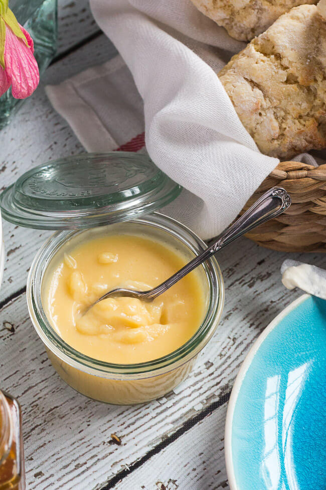 A pot of homemade lime curd and a basket of homemade scones.  