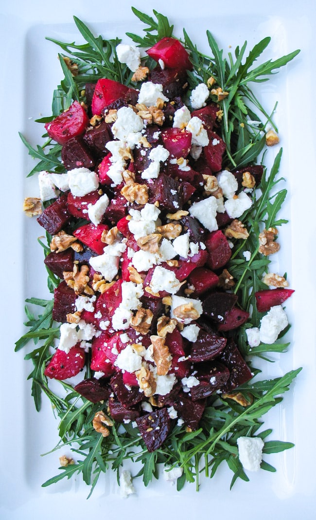 Overhead shot of Roasted Beetroot Salad with Goats Cheese & Walnuts on a white platter.