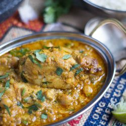 A silver Indian serving dish filled with slow cooker mild chicken curry.