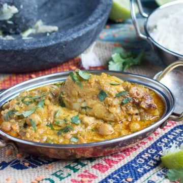 Cropped image of an Indian steel serving dish full of slow coker mild chicken curry with coconut milk.