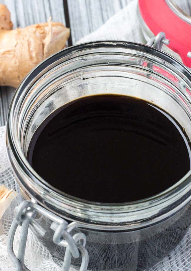 A glass clip top jar, half full of healthy teriyaki sauce. 