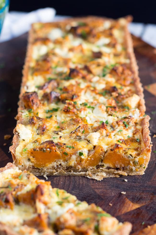 Shot of the cut end of a Sweet Potato, Feta & Caramelised Onion Tart, showing large pices of sweet potato and feta in the tart. 