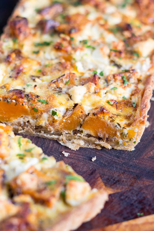 A close up of the cut edge of the Sweet Potato, Feta & Caramelised Onion Tart, clearly showing the creamy feta & sweet potato filling. 