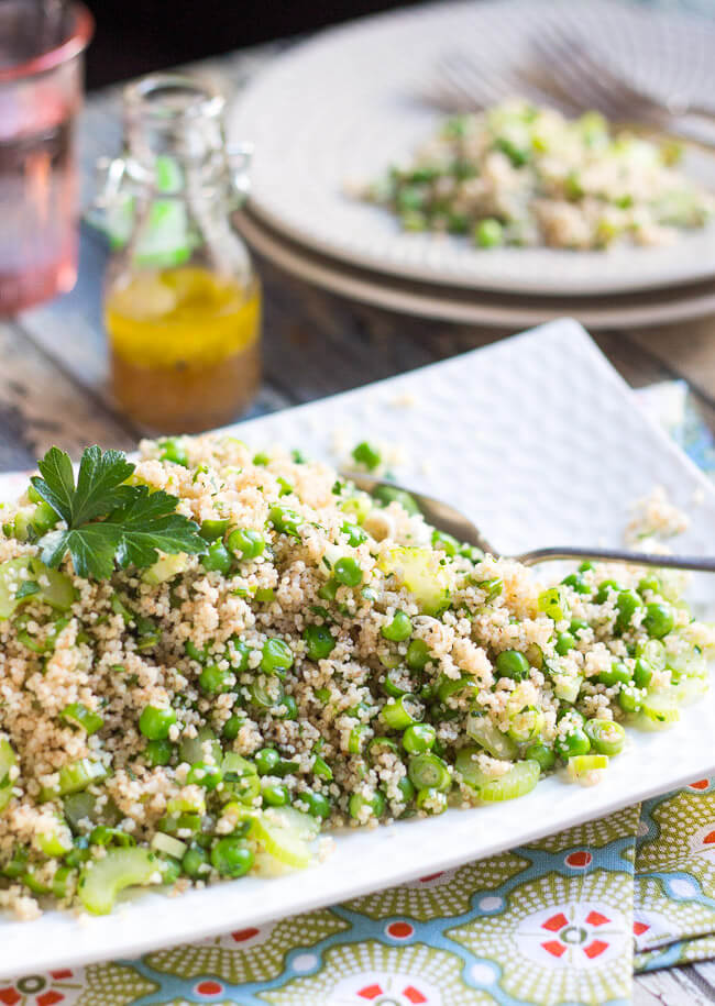 A heaped pile of an easy vegetable couscous salad recipe on a white platter.